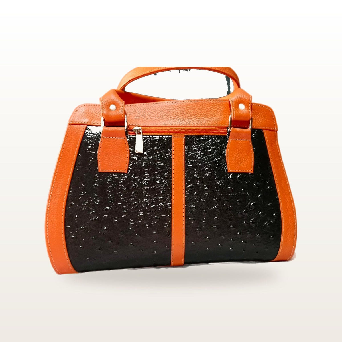 Orange and black leather handbag seen straight on, showing the top zip and handle tabs