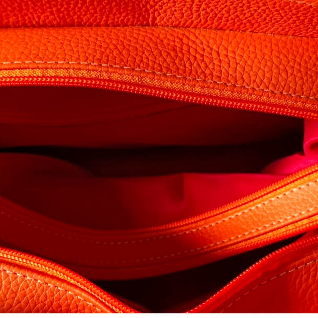 Interior of the handbag showing the zips dividing the three compartments