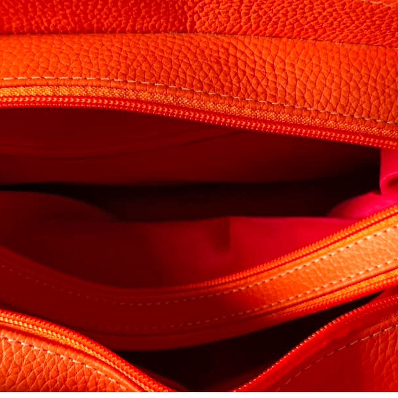 Interior of the handbag showing the zips dividing the three compartments