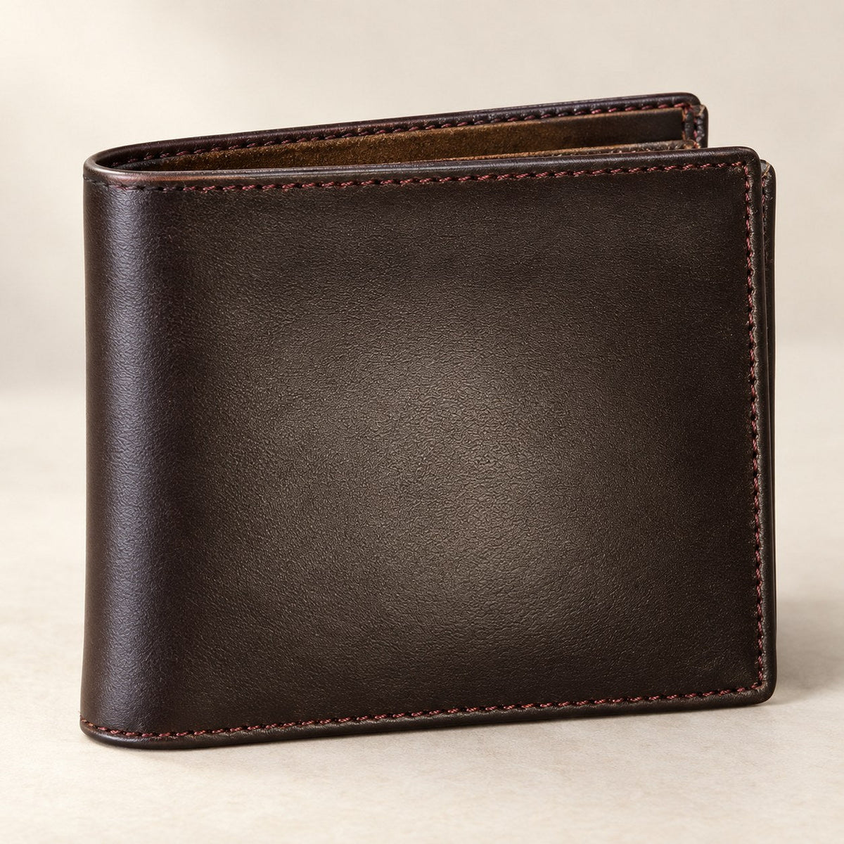 Men's dark brown leather bifold wallet with tan stitching, closed front view