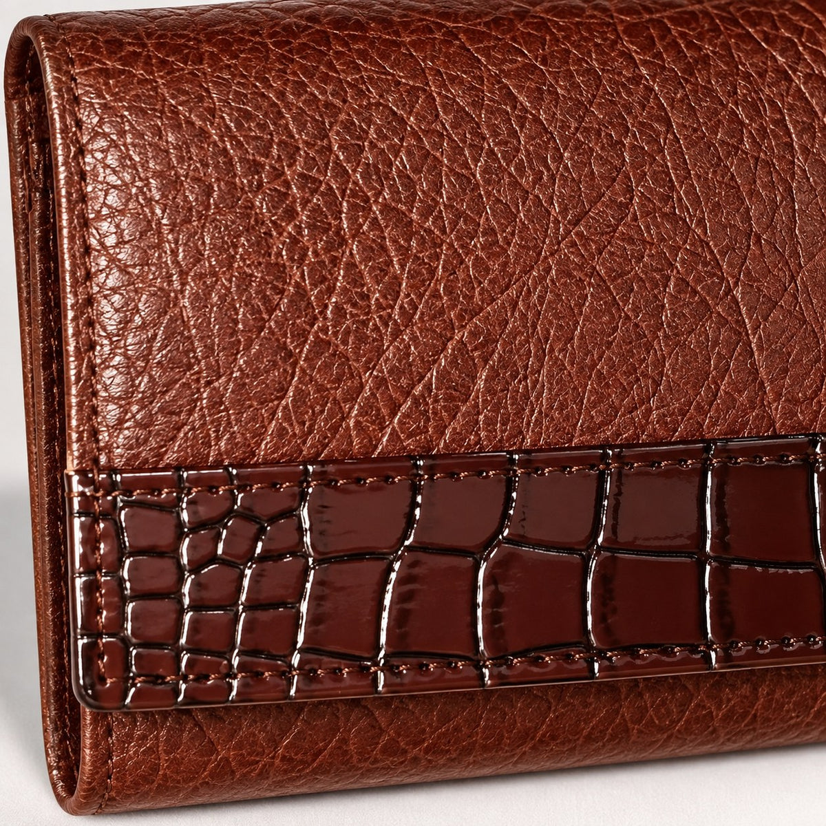 Close-up of the raised buffalo grain and the croc embossed band across the flap