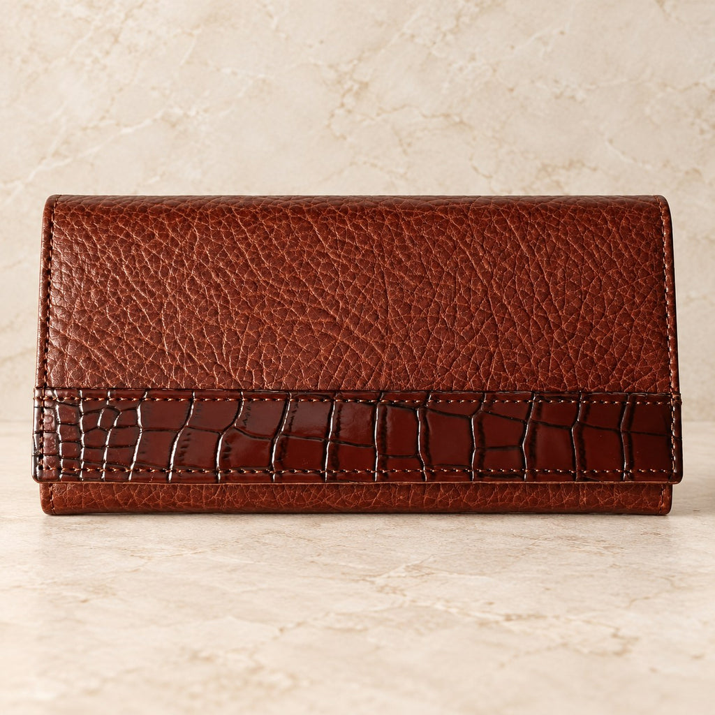 Buffalo grain leather clutch wallet displayed on a cream stone background