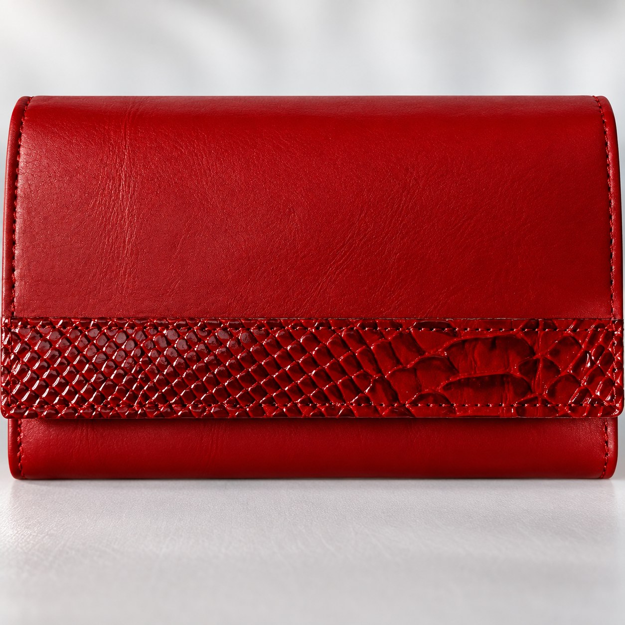 Close view of the croc grain embossed band on the red leather clutch wallet
