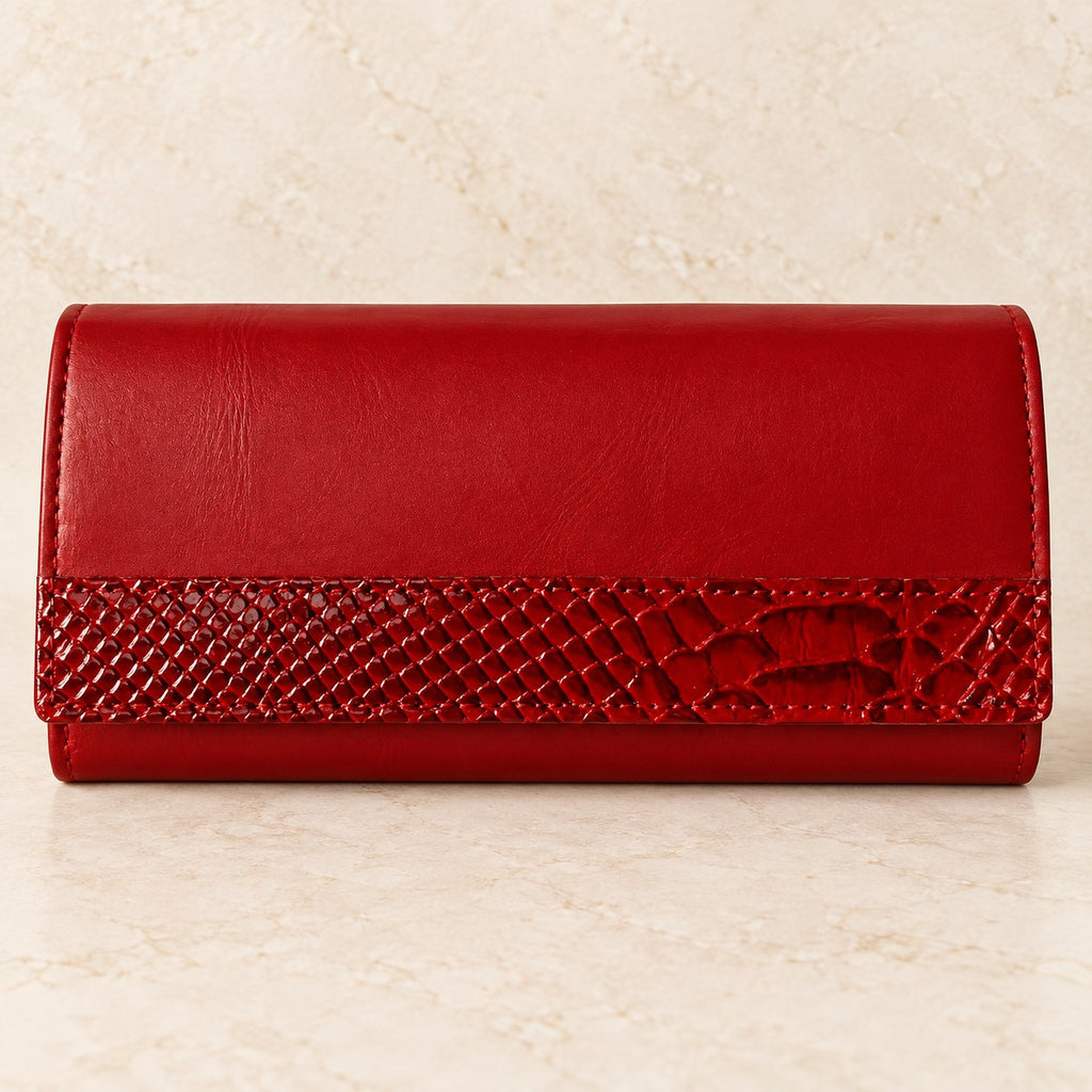 Red leather clutch wallet photographed on a cream stone surface