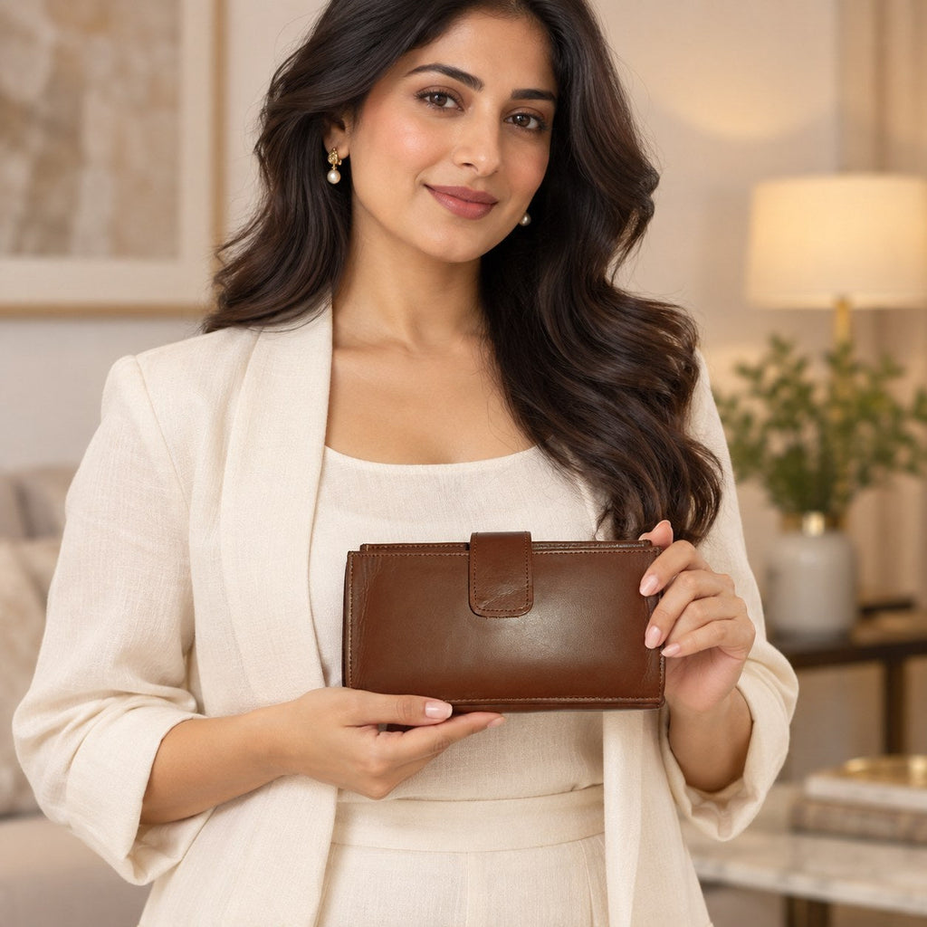 Woman in cream clothing holding the brown leather long wallet