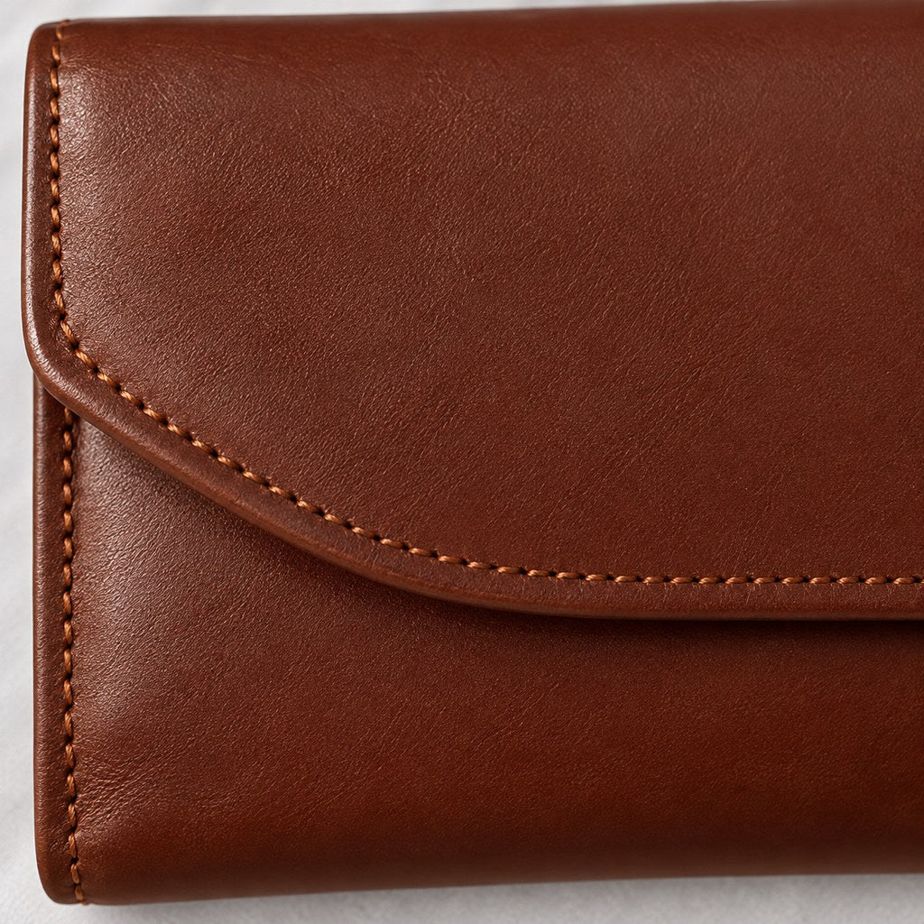 Close view of the tonal stitching and rounded flap edge on the brown envelope wallet