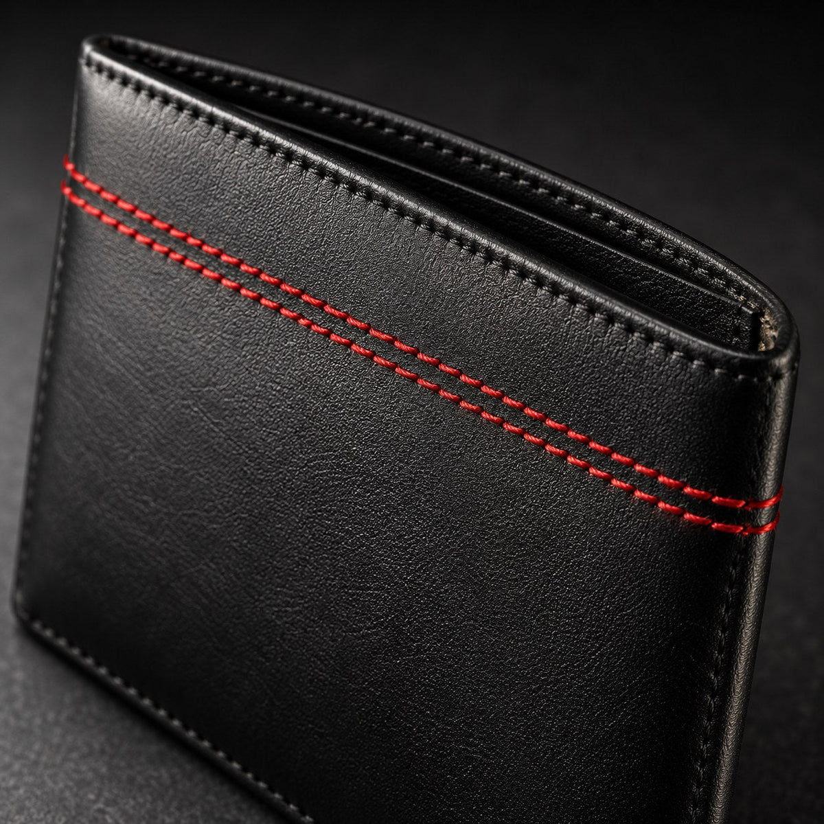 Close-up of the twin red stitch line across the front of the black leather wallet