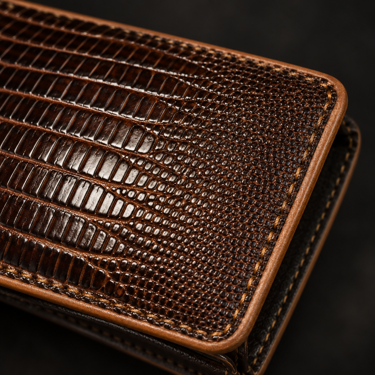 Close-up of the lizard-grain leather texture and contrast tan edge stitching