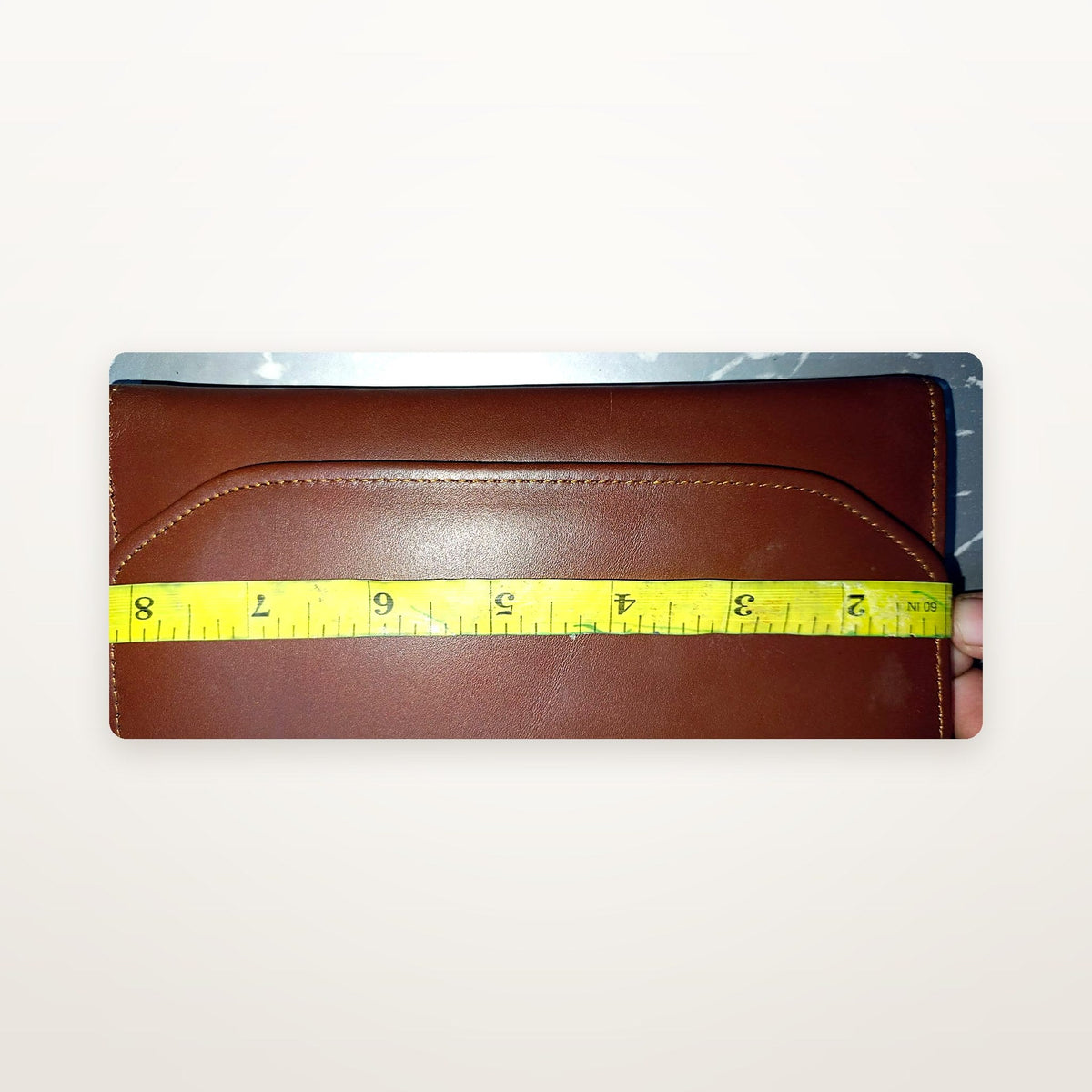 Chestnut leather envelope wallet with tape measure showing width