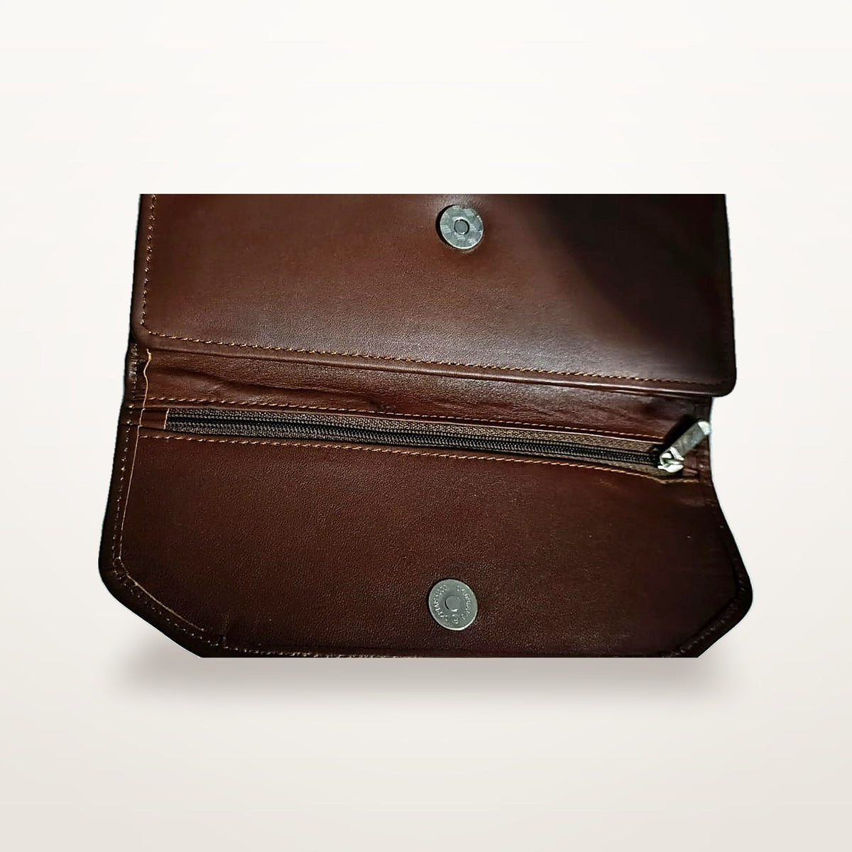 Chestnut leather trifold wallet open, showing twin press studs and zip pocket